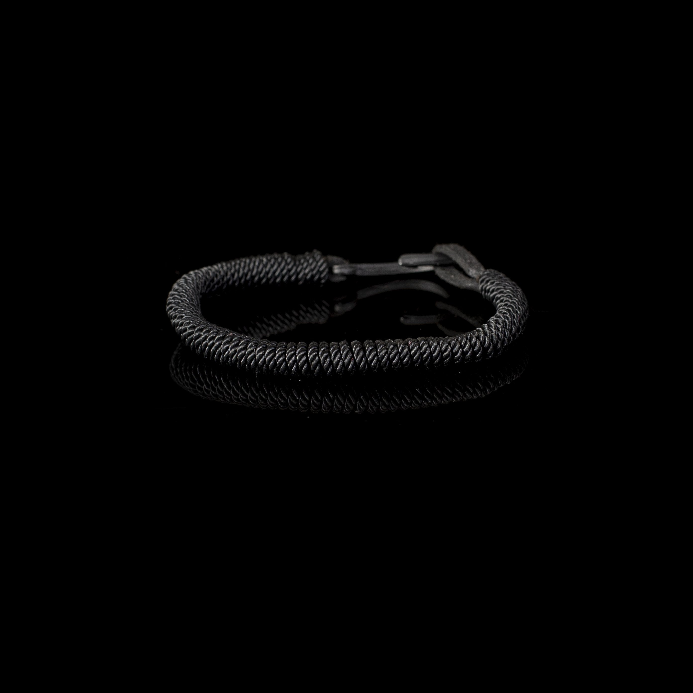 Handmade black coiled leather bracelet featuring a tightly wrapped spiral leather design with minimalist handcrafted detailing.