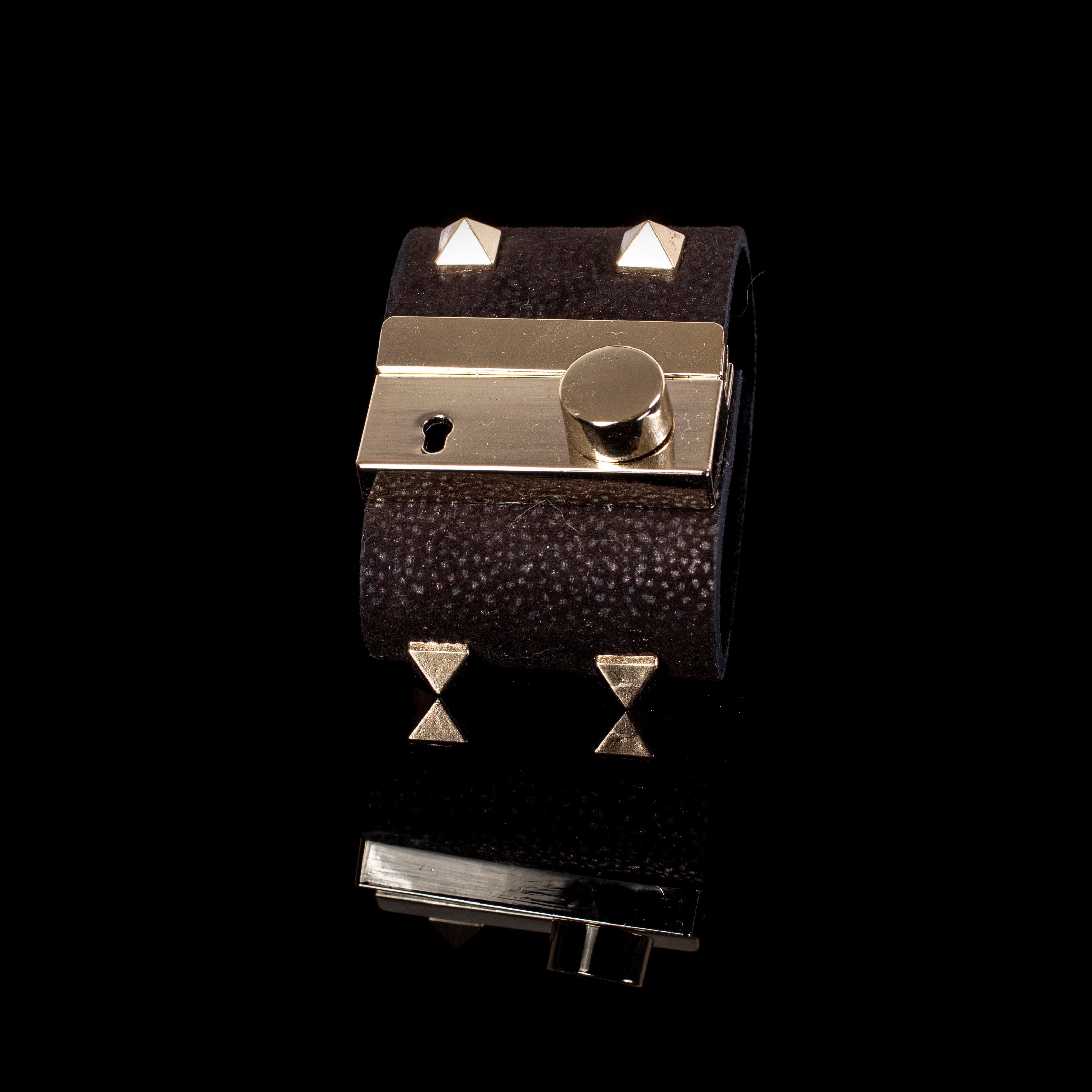 Black textured leather cuff bracelet with gold lock plate detail and pyramid studs, handcrafted wide statement bracelet for women