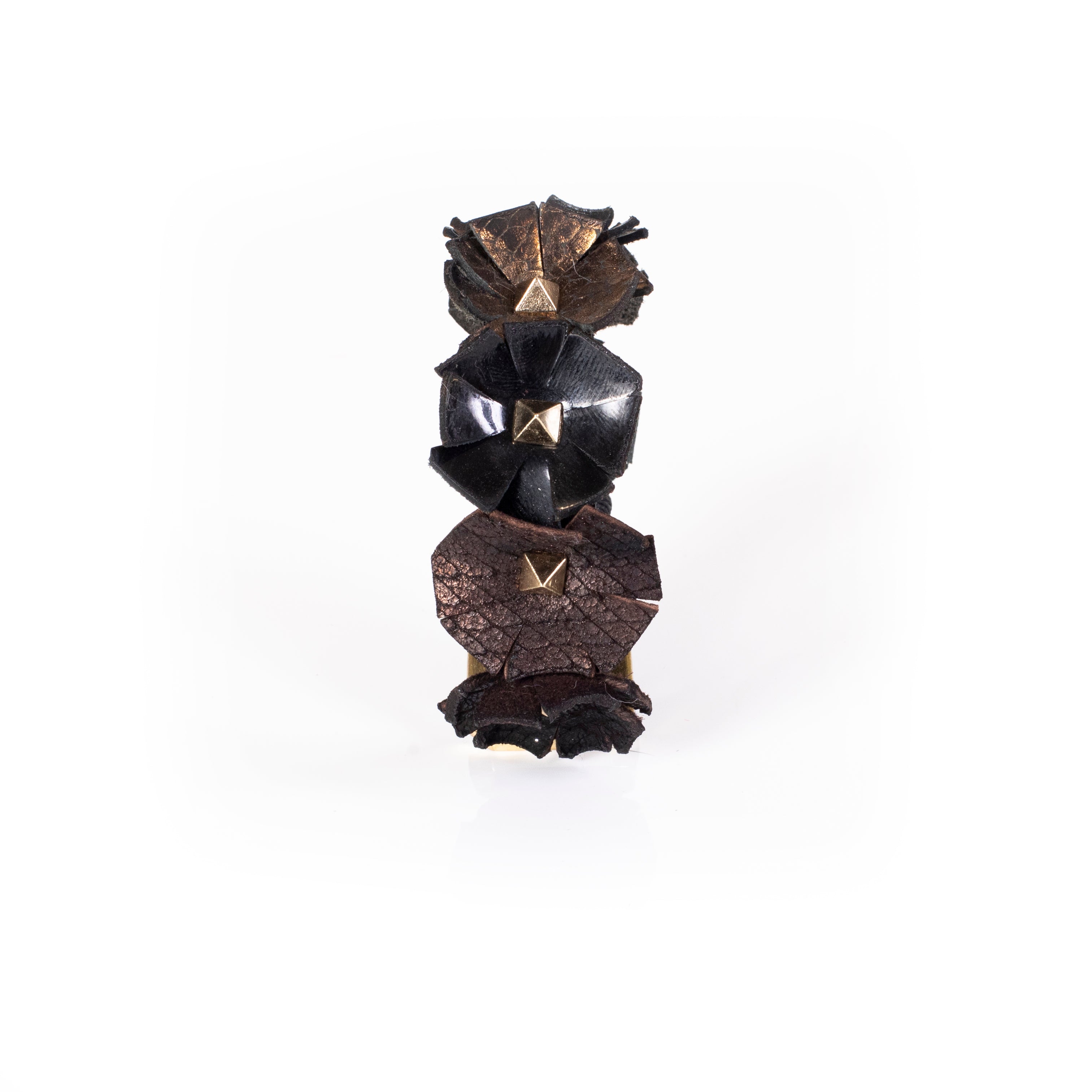 Black leather cuff with sculpted floral elements and gold pyramid studs