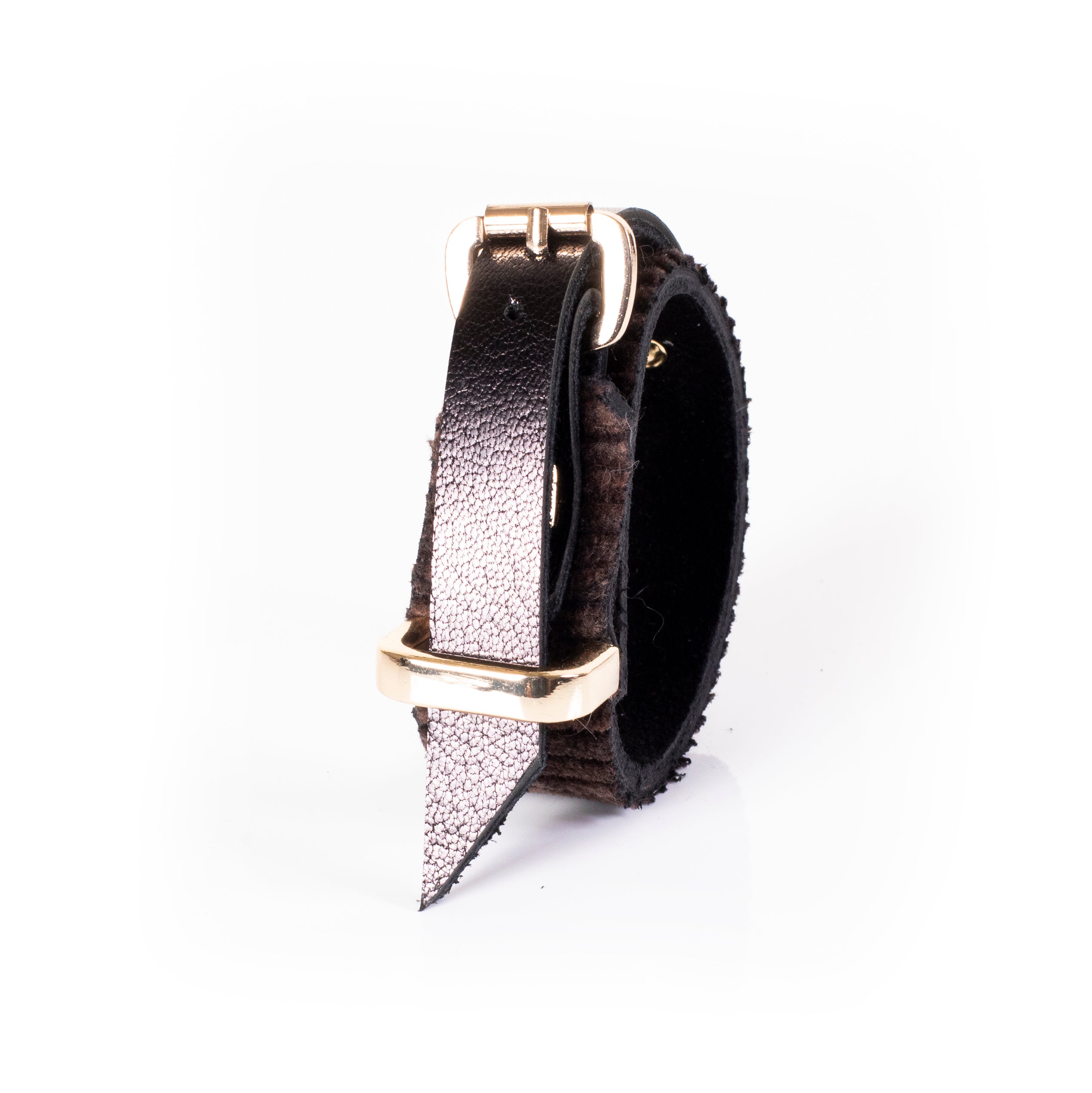 Brown textured leather cuff bracelet with ribbed surface, central strap detail, and gold pyramid stud, minimalist statement piece